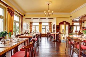 ein Restaurant mit Tischen und Stühlen in einem Zimmer in der Unterkunft Stadthotel Detmold in Detmold