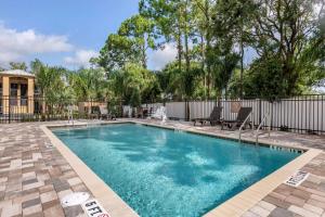 a swimming pool in a yard with a fence at Comfort Suites Daytona Beach-Speedway in Daytona Beach