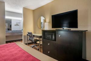a hotel room with a bed and a flat screen tv at Econo Lodge Sebring in Avon Park