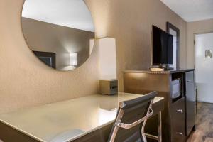 baño con escritorio con espejo y silla en Econo Lodge Sebring, en Avon Park