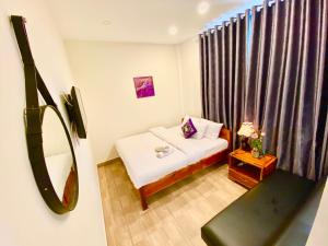 um pequeno quarto com uma cama e um espelho em Sweet Dream Hotel & Villa em Da Lat