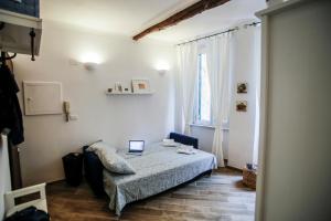 1 dormitorio con 1 cama con ordenador portátil en Vivi nel cuore del centro storico di Genova en Génova