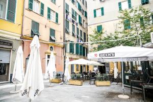 ulica z parasolami, stołami i krzesłami w obiekcie Vivi nel cuore del centro storico di Genova w Genui