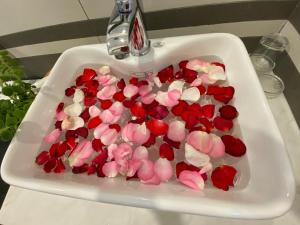 um lavatório com flores vermelhas e rosas em Sweet Dream Hotel & Villa em Da Lat