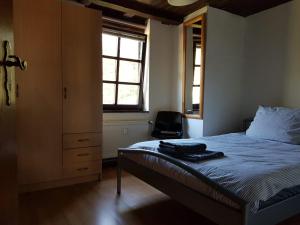 a bedroom with a bed and a dresser and a window at Das Alte Kneipchen in Oberhambach