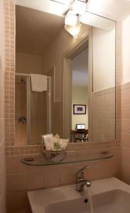 a bathroom with a sink and a large mirror at Albergo Orologio in Brescia