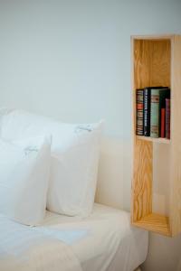 a bed with two pillows and a book shelf at Heirloom Hotels - A Flemish Tale in Ghent