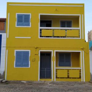 a yellow building with blue shutters on it at Ca' Santa Barbara, Free Wi-fi, Sea view, Sal Rei, Boa Vista, Cape Verde in Sal Rei
