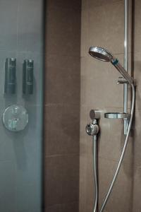 a shower with a shower head in a bathroom at Heirloom Hotels - A Flemish Tale in Ghent