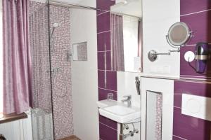 a bathroom with a shower, sink, and mirror at Hotel Torwirt in Wolfsberg