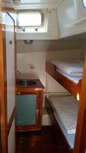 Cette petite chambre comprend 2 lits superposés et un lavabo. dans l'établissement Tjalkjacht Pelikaan Lemmer, à Lemmer