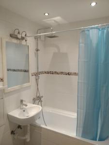 une salle de bain avec un lavabo, une baignoire et une douche dans l'établissement Studija Centre, à Klaipėda