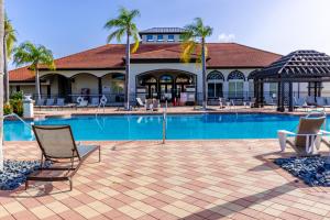 a swimming pool with chairs and a building at Fantastic Lakeview Townhome near Disney in Kissimmee