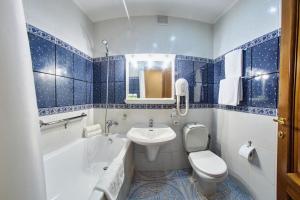 a blue and white bathroom with a sink and a toilet at Art Hotel Academy in Dnipro