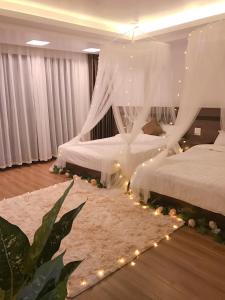 a bedroom with two beds with lights and a rug at Wind House Hotel in Sa Pa
