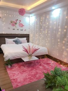 Wind House Hotel في سابا: غرفة نوم بسرير وسجادة وردية