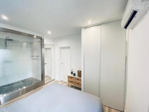 een slaapkamer met een grote douche en een bed bij CAUVI - Antibes Centre, WIFI, Climatisation, 4 personnes in Antibes