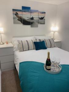a bed with a tray with a bottle of wine and glasses at Salty Toes in Paignton