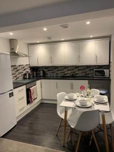 a kitchen with a white table and white cabinets at Salty Toes in Paignton