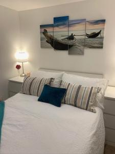 a bedroom with a bed with three paintings on the wall at Salty Toes in Paignton