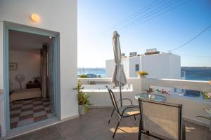 a balcony with a table and chairs and a view of the ocean at Emily's Suites in Adamantas