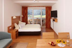 1 dormitorio con 1 cama y sala de estar en Kolbitsch am Weissensee ein Ausblick der verzaubert, en Weissensee