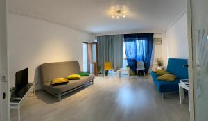 ブカレストにあるGreen Apartment 4 Mircea Vodaのリビングルーム(ソファ、青い椅子付)