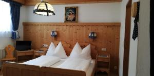 1 dormitorio con 1 cama grande con almohadas blancas en Ferienwohnungen Kirchler en Vorderlanersbach