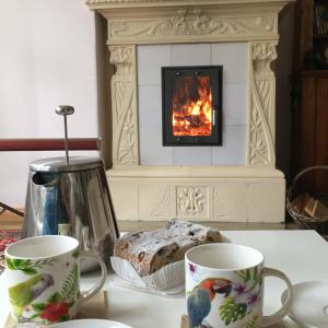 two cups on a table in front of a fireplace at Villa Harmonie in Ahlbeck