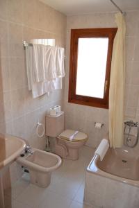 a bathroom with a sink and a toilet and a window at San Marcos in Huesca