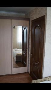 a bedroom with a mirror and a door at Hotel Garmonia in Pskov