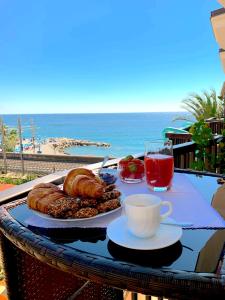 - une table avec une assiette de pain et une tasse de café dans l'établissement La Gaviota - Bilocale sul mare in Arziglia, à Bordighera