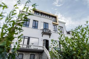 a white house with a balcony on top of it at Hôtel Vedette in Profondeville