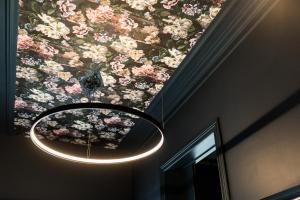 a chandelier hanging from a ceiling with flowers at Hôtel Vedette in Profondeville