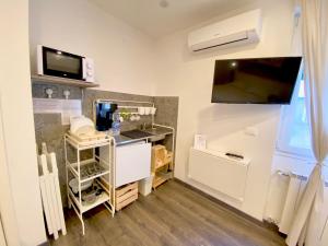 Kleines Zimmer mit einem Schreibtisch und einem TV an der Wand. in der Unterkunft Mimì Rooms&Studios in Triest