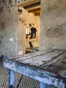 Casa rural La Montañeta Alta في أنتيغوا: غرفة حجرية مع طاولة خشبية في الغرفة