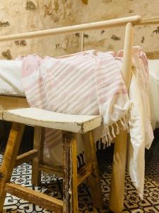 a wooden chair sitting next to a bed at Casa Rural La Montañeta Alta in Antigua +13 photos