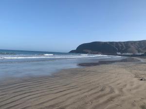 a sandy beach with waves in the ocean at Casa rural La Montañeta Alta in Antigua