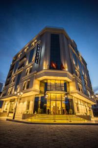 a large building with lights on the front of it at HOTEL PALAIS ROYAL in Sfax