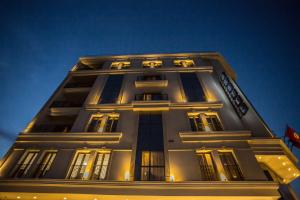 ein hohes Gebäude mit einer Uhr in der Nacht in der Unterkunft HOTEL PALAIS ROYAL in Sfax