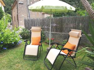 ピエトラサンタにあるLa Bouganville e Il Gelsominoの庭の椅子2脚と傘