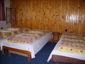 2 Betten in einem Zimmer mit Holzwänden in der Unterkunft Chalupa Praženica in Liptovské Revúce