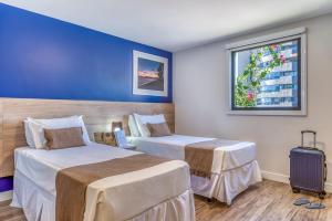 Postel nebo postele na pokoji v ubytování Cais da Praia Hotel