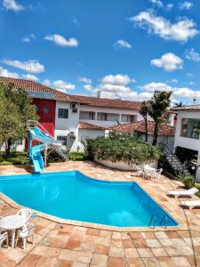 una piscina azul con un tobogán en un patio en Hotel Portal De Eunápolis, en Eunápolis