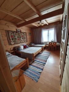 a room with two beds and a table in a cabin at Pokoje i Apartamenty Regionalny Styl ul Bachledy 41 Zakopane in Zakopane