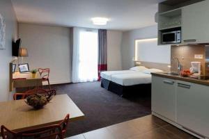 um quarto de hotel com uma cama e uma cozinha em Apartement 24, Hotell em Estocolmo