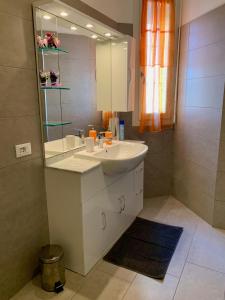 a bathroom with a white sink and a mirror at Ennodio Apartment in Como