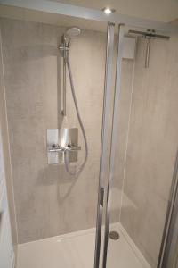 una ducha con puerta de cristal en un baño en Floating vacationhome Tenerife, en Maastricht