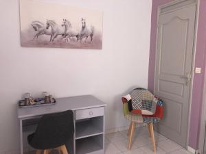um quarto com uma secretária e uma pintura de cavalos na parede em Mawima em Vieux-Habitants