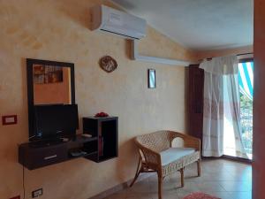 a living room with a tv and a chair at B&B Sa Funtana in Cardedu
